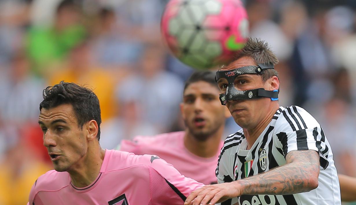 Striker Juventus, Mario Mandzukic, duel udara dengan pemain Palermo pada laga Serie A di Stadion Juventus, Turin, Minggu (17/4/2016). Kemenangan ini membuat Juve kian kokoh di puncak klasemen. (AFP/Marco Bertorello)