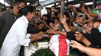 Presiden Joko Widodo atau Jokowi membagikan bantuan langsung tunai bagi para pedagang kaki lima dan warung di Pasar Kebun Lada Kota Binjai, Sumatera Utara, Jumat (4/2/2022).