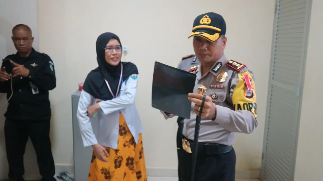 Kapolres Gowa AKBP Shinto sedang melihat hasil rontgen perut Akmal, remaja di Gowa yang bertelur (Liputan6.com/ Eka Hakim)