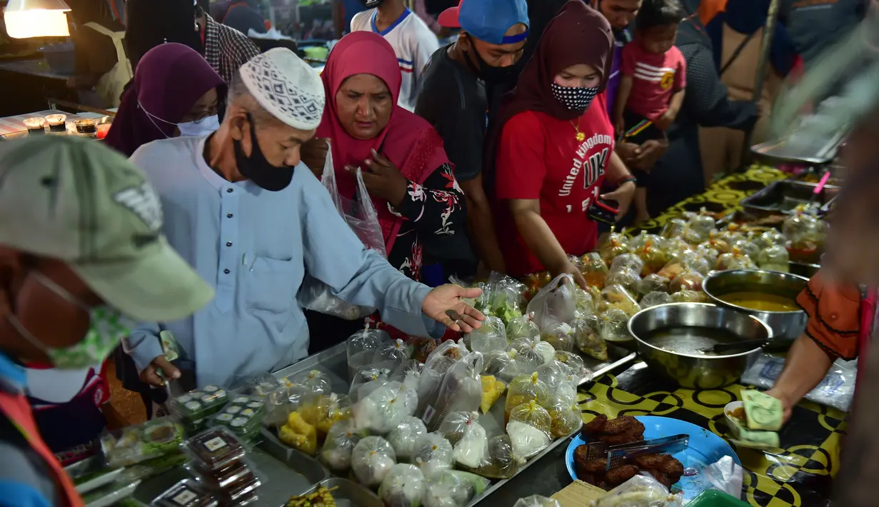 Orang-orang berbelanja di pasar makanan pada hari pertama bulan suci Ramadhan di provinsi Narathiwat di Thailand selatan (24/4/2020). Sejumlah pedagang menjual berbagai makanan selama bulan suci Ramadan di pasar tersebut. (AFP/Madaree Tohlala)