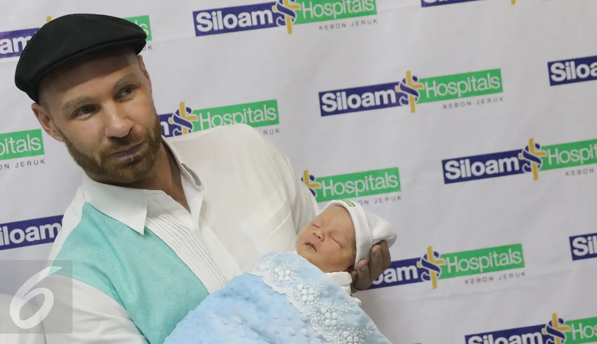 Tyson Lynch, suami Melaney Ricardo, menggendong bayi laki-laki mereka usai konferensi pers di RS Siloam Kebon Jeruk, Jakarta, Kamis (5/5). Tyson mengatakan, nama tengah anak keduanya diambil dari nama Michael Jordan. (Liputan6.com/Herman Zakharia)