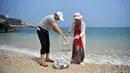 Turis mengumpulkan sampah di sepanjang Teluk Mulan, Kota Wenchang, Provinsi Hainan, China pada 28 April 2020. Fasilitas bank sampah dibuat dengan wisatawan dapat menukarkan sampah yang mereka kumpulkan di pantai dengan hadiah, seperti air kemasan, kelapa serta makanan ringan. (Xinhua/Guo Cheng)