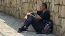 Seorang pria duduk di tempat teduh di balik dinding selama cuaca panas di Madrid, Spanyol, Rabu (13/7/2022). Ramalan cuaca setempat mengatakan Spanyol diperkirakan akan mengalami gelombang panas kedua dalam waktu kurang dari sebulan dan itu akan berlangsung setidaknya sampai akhir pekan. (AP Photo/Paul White)
