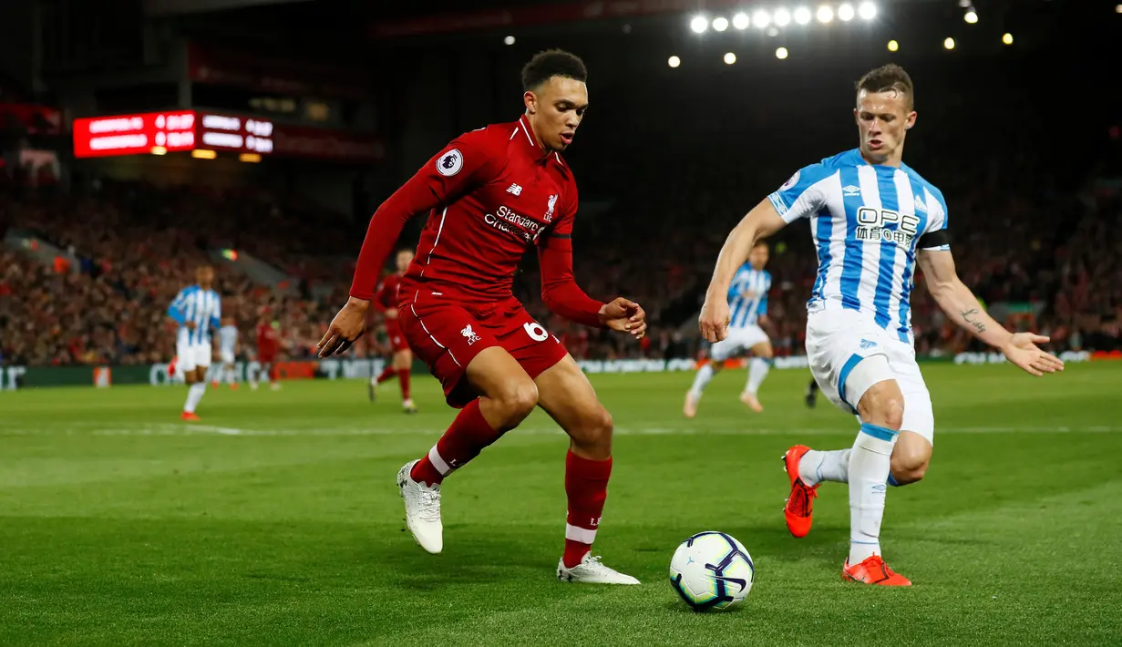 Bek  Liverpool, Trent Alexander-Arnold, berebut bola dengan pemain Huddersfield Town, Jonathan Hogg dalam laga lanjutan Premier League 2018-19 pekan ke-36 di Anfield, Jumat (26/4). Bermain di kandang sendiri, Liverpool menang dengan skor telak 5-0.  (REUTERS/Andrew Yates)