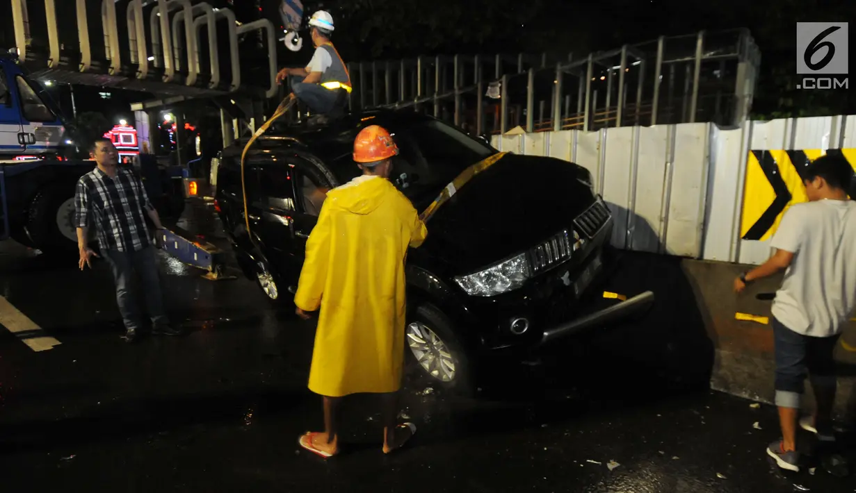 Petugas mengevakuasi mobil pajero yang menabrak pagar pembatas pembangunan proyek  stasiun Mass Rapid Transit (MRT) di belakang Polda Metro Jaya, Jakarta, Jumat (25/1). Tidak ada korban jiwa dalam kecelakaan tunggal tersebut. (Merdeka.com/Dwi Narwoko)