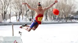 Seorang pria saat melompat ke danau yang beku di Shenyang di provinsi Liaoning, China timur laut (2/3). (AFP Photo)