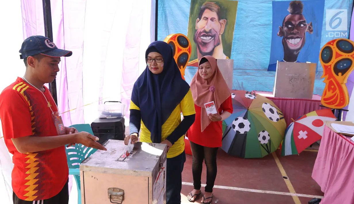 Pemilih memasukkan surat suara setelah mencoblos pada Pilkada Serentak 2018 di TPS 29 Gandasari, Kota Tangerang, Rabu (27/6). Di TPS ini warga yang memilih untuk Pilkada Kota Tangerang dapat merasakan sensasi Piala Dunia 2018 (Liputan6.com/Angga Yuniar)