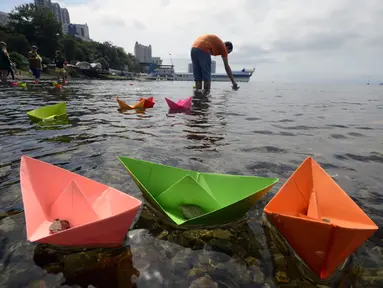 Beberapa warga meluncurkan perahu kertas saat perayaan ulang tahun ke-69 akhir Perang Dunia II di Vladivostok, (2/9/2014). (REUTERS/Yuri Maltsev)