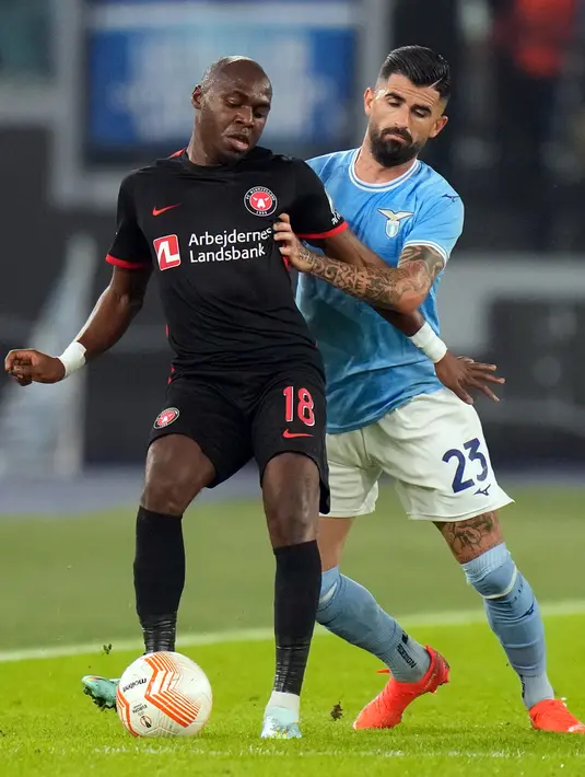 Pemain FC Midtjylland Edward Chilufya (kiri) berebut bola dengan pemain Lazio Elseid Hysaj pada pertandingan sepak bola Grup F Liga Europa di Stadion Olimpiade Roma, Italia, 27 Oktober 2022. Lazio menang 2-1 atas FC Midtjylland. (AP Photo/Alessandra Tarantino)