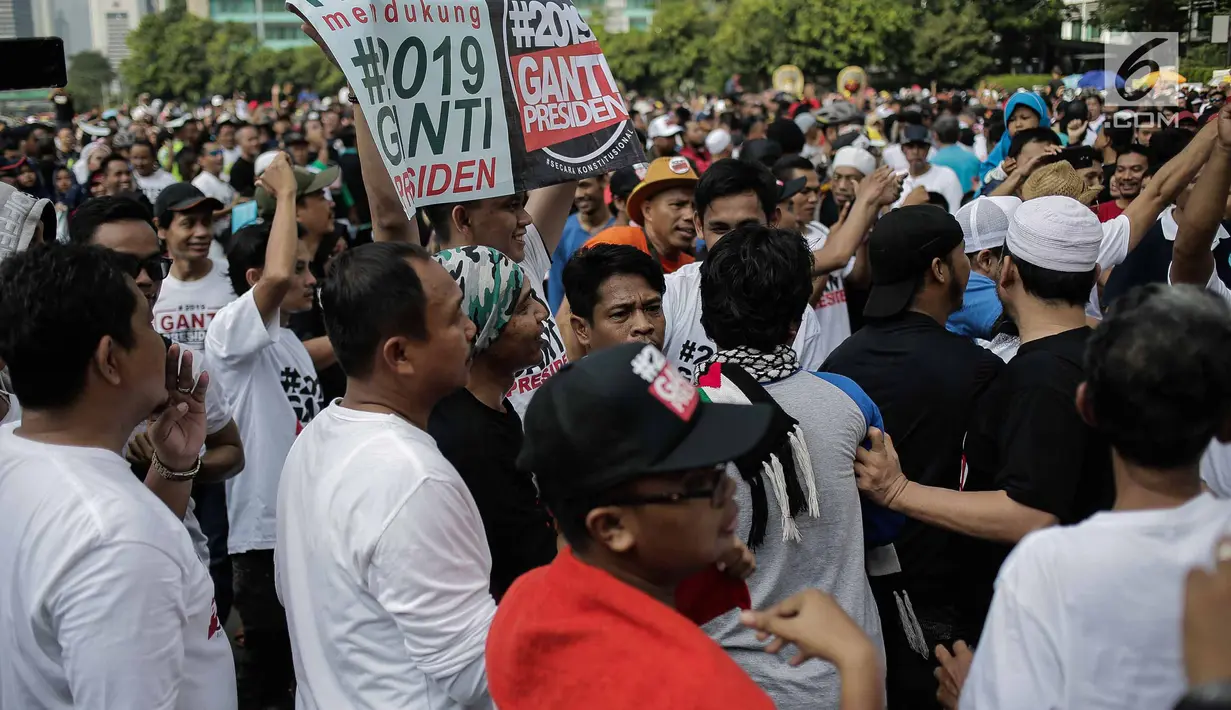 Massa yang mengenakan kaus #2019GantiPresiden bertemu dengan peserta jalan sehat #DiaSibukKerja pada kegiatan Car Free Day di Bundaran HI, Jakarta, Minggu (29/4). Saling sindir tak terelakan saat kedua aksi ini bertemu. (Liputan6.com/Faizal Fanani)