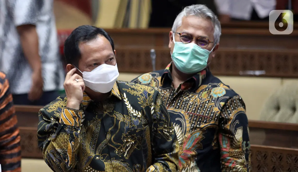 Mendagri Tito Karnavian (kiri) bersama Ketua KPU Arief Budiman sebelum mengikuti rapat kerja dengan Komisi II DPR di Kompleks Parlemen, Senayan, Jakarta, Kamis (26/11/2020). Rapat itu membahasan data kependudukan dan data pemilih Pilkada Serentak 2020. (Liputan6.com/Johan Tallo)