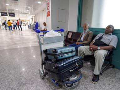 Wisatawan menunggu dengan barang bawaan mereka setelah penerbangan dibatalkan karena aksi mogok massal pekerja di Bandara Internasional Tunis-Carthage Tunisia, Kamis (16/6/2022). Serikat Pekerja Umum Tunisia (UGTT) mengadakan aksi mogok massal pada hari Kamis ini menuntut kenaikan gaji dan konsesi. (FETHI BELAID / AFP)