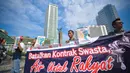 Aktivis Koalisi Masyarakat Menolak Swastanisasi Air Jakarta membentangkan spanduk saat menggelar aksi Menolak Swastanisasi Air Jakarta di Bundaran HI, Jakarta, Minggu (22/3/2015). (Liputan6.com/Faizal Fanani) 