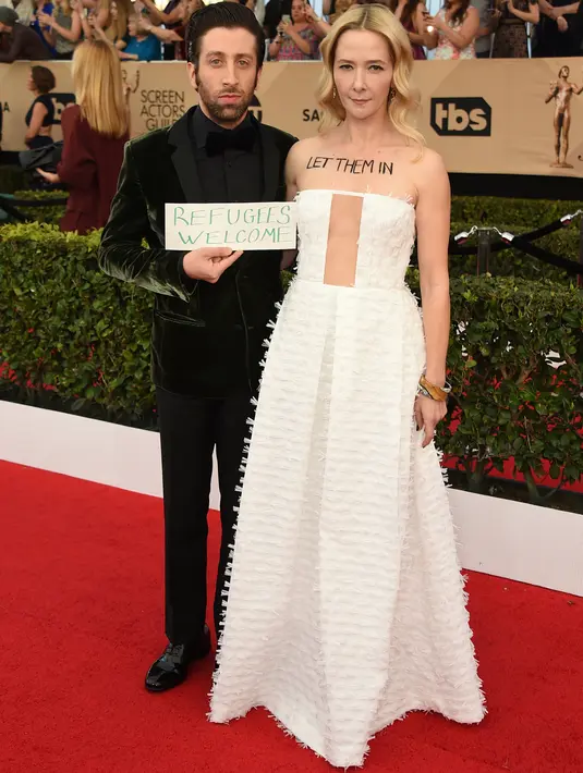 Aktor Simon Helberg dan istri, Jocelyn Towne menarik perhatian di karpet merah ajang SAG Awards di Los Angeles, Minggu (29/1). Istri bintang 'The Big Bang Theory' tersebut menuliskan kalimat 'Let Them In' di atas dadanya. (Jordan Strauss/Invision/AP)
