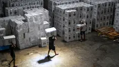 Pekerja menata kotak suara yang berisi surat suara sebelum dimasukkan ke dalam truk untuk didistribusikan ke kecamatan-kecamatan di gudang Komisi Pemilihan Umum (KPU) di Surabaya pada 5 Februari 2024. (Juni KRISWANTO/AFP)