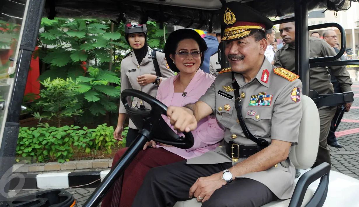 Jenderal Badrodin Haiti didampingi istrinya, menaiki mobil golf menuju tempat upacara sertijab Kapolri di Stadion PTIK, Jakarta, Kamis (14/7). Badrodin resmi menyerahkan tongkat komando Kapolri kepada Jenderal Tito Karnavian. (Liputan6.com/Helmi Afandi)