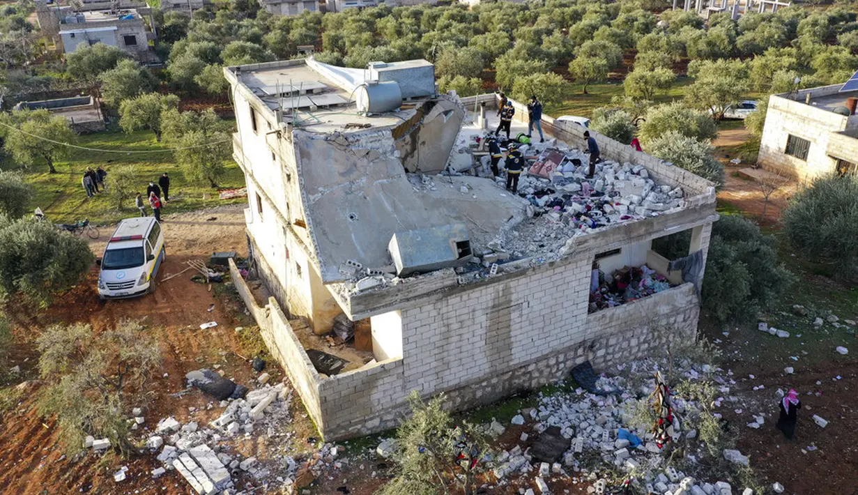Orang-orang memeriksa rumah yang hancur setelah operasi militer AS di Atmeh, Provinsi Idlib, Suriah, 3 Februari 2022. Pasukan khusus AS melakukan serangan kontraterorisme skala besar yang menewaskan banyak orang di lokasi tersebut. (AP Photo/Ghaith Alsayed)