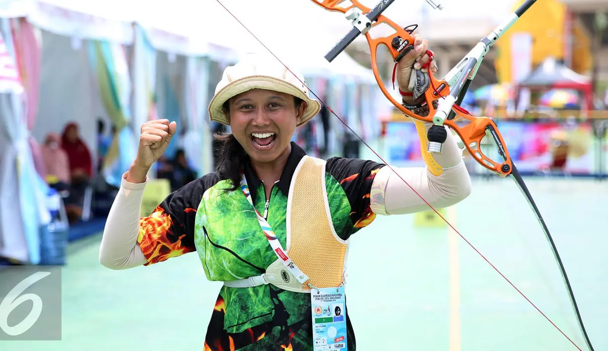 Pemanah Jatim Eka Yuliana mengangkat tangan usai memastikan meraih emas kelas Recurve Women Individual di Lapangan Panahan Si Jalak Harupat, Kab Bandung, Rabu (21/9). Di final, Yuliana mengalahkan Rina D Puspitasari. (Liputan6.com/Helmi Fithriansyah)