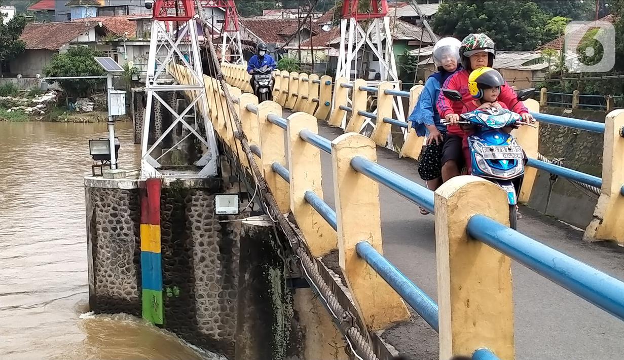 Pengendara sepeda motor melintasi Bendung Katulampa, Bogor, Jawa Barat, Senin (10/10/2022). Setelah sebelumnya tinggi muka air (TMA) mencapai 220 Cm dengan status Siaga 1, pada pukul 13.23 WIB Bendung Katulampa terpantau kembali pada status normal. (Liputan.com/Magang/Aida Nuralifa)