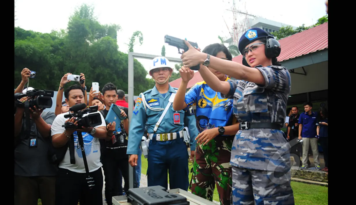Penyanyi dangdut Dewi Perssik mengikuti lomba menembak bersama KSAL Laksamana TNI Ade Supandi, di Lapangan Tembak Mabesal, Cilangkap, Jakarta, Jumat (27/2/2015). (Liputan6.com/Yoppy Renato)