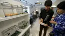 Pelanggan memilih ular yang untuk menemaninya makan di sebuah kafe ular 'Tokyo Snake Center' di distrik fashion Harajuku, Tokyo, 14 Agustus 2015. Di kafe ini, pengunjung bisa menikmati aneka hidangan sambil ditemani ular. (REUTERS/Toru Hanai)