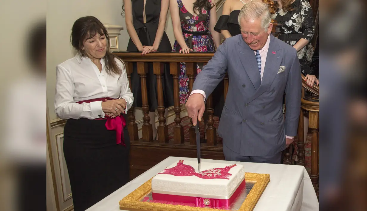 Pangeran Charles bersama pendiri Walk the Walk Nina Barough memotong kue bergambar bra saat menghadiri perayaan ulang tahun ke-20 Walk the Walk di Clarence House, London (23/11). (AFP PHOTO/POOL/Arthur Edwards)