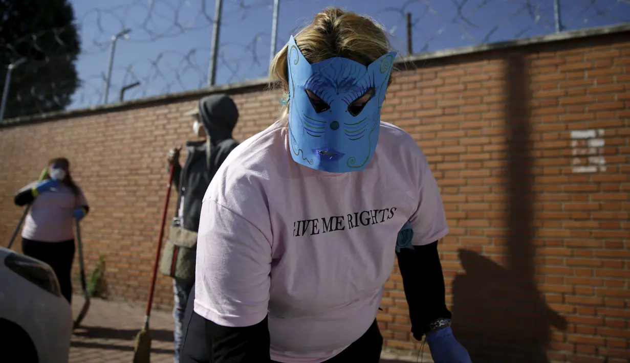 Seorang wanita memakai topeng sambil membersihkan jalanan kota madrid, Spanyol , Rabu  (14/10/2015).  Hal ini merupakan sikap protes terhadap pandangan masyrakat terhadap para PSK ini. . (REUTERS/Andrea Comas)