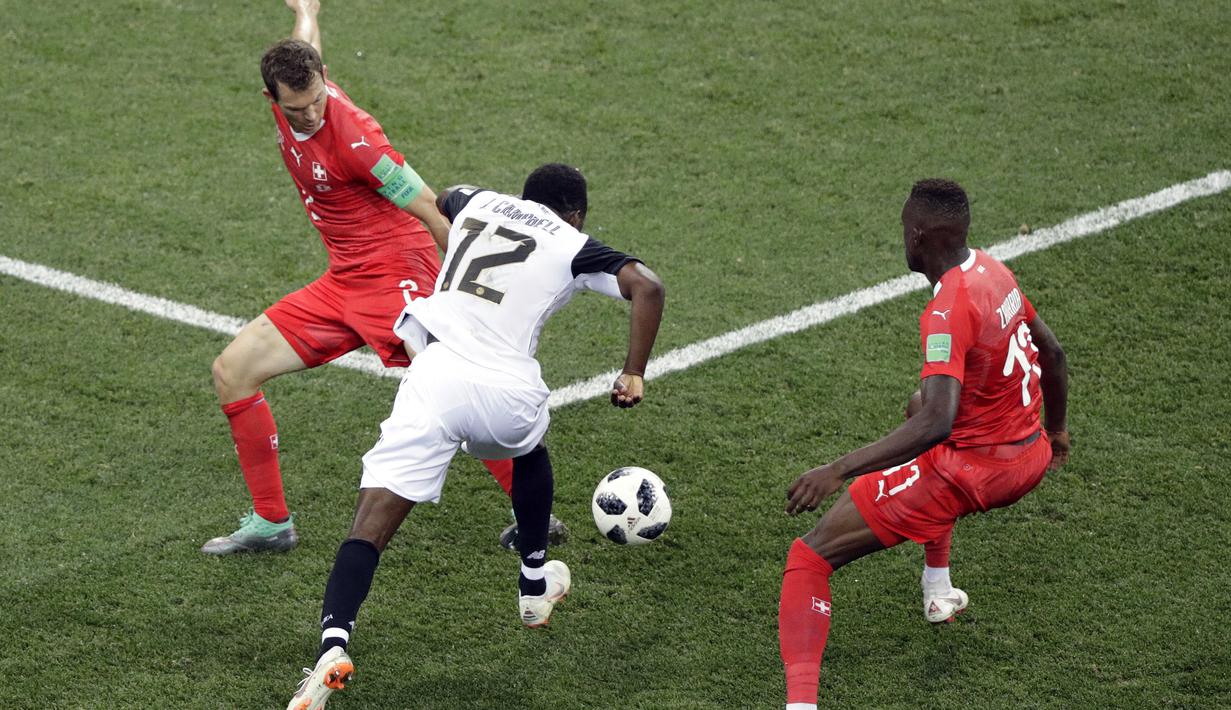 Pemain Kosta Rika, Joel Campbell melewati adangan dua pemain Swiss pada laga grup E Piala Dunia 2018 di Nizhny Novgorod Stadium, Nizhny Novgorod, Rusia, (27/6/2018). Swiss bermain imbang 2-2 dengan Los Ticos. (AP/Mark Baker)