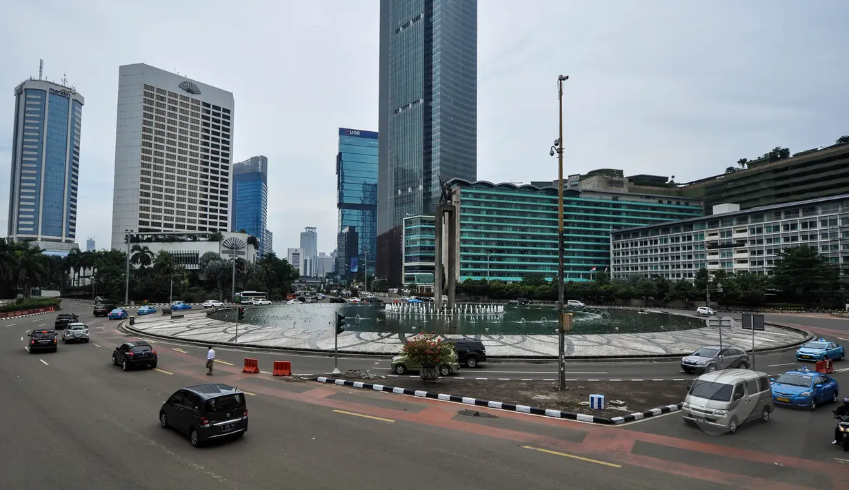 Sejumlah kendaraan saat melintas di kawasan Bundaran HI, Jakarta, Jumat (3/4/2015).  Kondisi jalanan lengang disebabkan libur panjang yang bertepatan libur paskah dan banyaknya masyarakat Jakarta yang berlibur ke luar kota. (Liputan6.com/ Faizal Fanani)