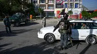 Petugas keamanan menghentikan pengendara mobil saat Hari Raya Idul Fitri di pos pemeriksaan di Kabul, Afghanistan, Minggu (24/5/2020). Taliban mengumumkan gencatan senjata selama tiga hari dengan pemerintah Afghanistan setelah berbulan-bulan bertempur. (WAKIL KOHSAR/AFP)