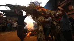 Umat Hindu Nepal membawa jerami untuk dibakar dalam perayaan Ghanta Karna di Bhaktapur di pinggiran Kathmandu, Nepal (21/7). Ritual ini untuk merayakan kekalahan iblis dalam mitos Ghanta Karna. (AFP Photo/Gopen Rai)