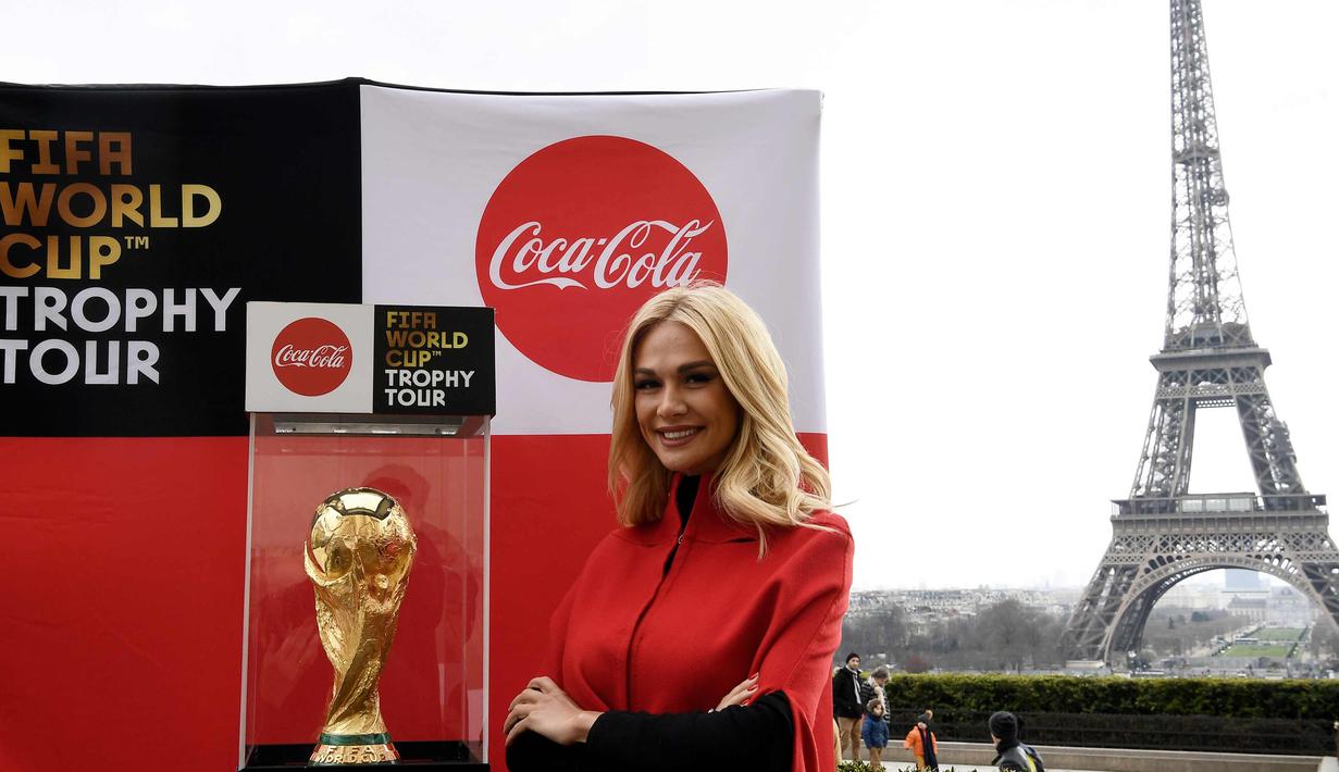 Duta Besar FIFA World Cup 2018, Victoria Lopyreva berpose dengan trofi Piala Dunia dengan latar menara Eiffel selama FIFA World Cup Trophy Tour di Paris (20/3). Piala Dunia 2018 diselenggarakan 14 Juni dan 15 Juli 2018 di Rusia. (AFP Photo/Franck Fife)
