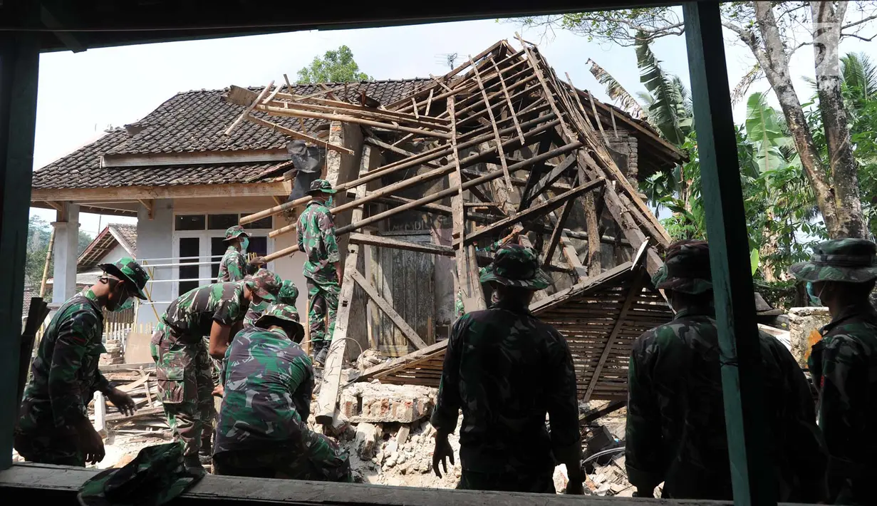 Anggota Yonif 320 Badak Putih Prajurit Jawara Kodam III Siliwangi membantu membersihkan reruntuhan bangunan usai gempa di Mandalawangi, Pandeglang, Banten, Sabtu (3/8/2019). Gempa Banten berkekuatan 6,9 magnitudo mengakibatkan lebih dari 200 rumah mengalami kerusakan. (merdeka.com/Arie Basuki)