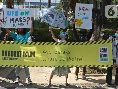 Para peserta aksi Asia Climate Rally menggelar unjuk rasa depan Balai Kota DKI Jakarta, Jumat (27/11/2020). Mereka meminta pemerintah melakukan tindakan nyata dalam penyelamatan iklim, salah satunya dengan berhenti mendanai industri bahan bakar fosil yang mematikan. (Liputan6.com/Hermann Zakharia)