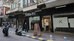 Orang-orang berjalan melewati toko-toko yang tutup atau setengah buka di kawasan Burj Hammoud, Beirut, Lebanon, 14 Desember 2021. Semarak jelang Natal yang biasa terjadi di Beirut, tak lagi terasa tahun ini karena krisis keuangan terburuk di Lebanon. (JOSEPH EID/AFP)