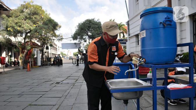 Petugas menyiapkan fasilitas cuci tangan yang disediakan di tiap pintu masuk kompleks wisata Kota Tua, Jakarta, Selasa (2/6/2020). Jelang berakhirnya PSBB di Jakarta, pengelola Kota Tua menyiapkan protokol kesehatan new normal bagi pengunjung. (merdeka.com/Iqbal S. Nugroho)