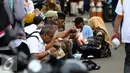 Sejumlah massa aksi makan siang sebelum memulai aksi di Medan Merdeka Timur, Jakarta, Jumat (4/11). Massa melakukan aksi di depan Istana Negara menuntut penegakan hukum kasus dugaan penistaan agama. (Liputan6.com/Faizal Fanani)