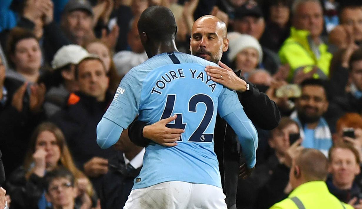 Pelatih Manchester City, Pep Guardiola, memeluk Yaya Toure usai laga melawan Brighton and Hove Albion di Stadion Etihad, Rabu (9/5/2018). Laga tersebut menjadi ajang perpisahan sang pemain bersama The Citizens. (AFP/Paul Ellis)