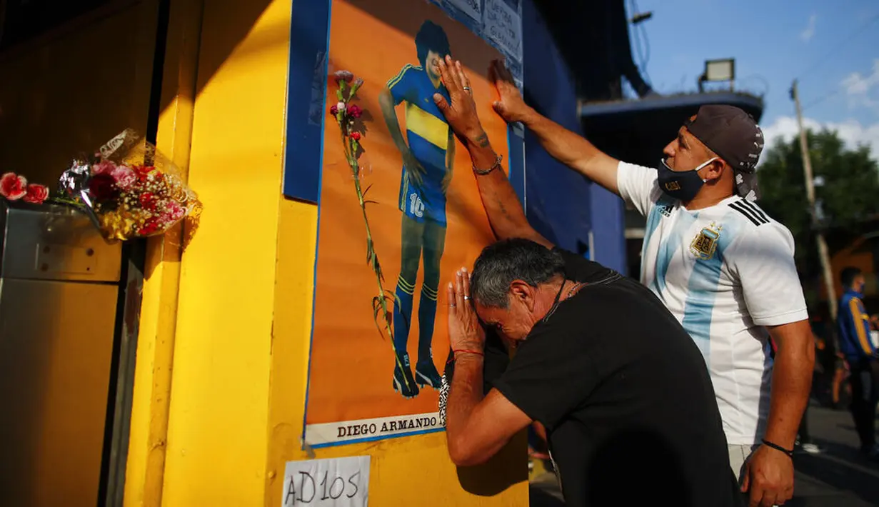 Dua orang fans tampak sedih usai meninggalnya Diego Maradona di Buenos Aires, Argentina, Rabu (25/11/2020). legenda sepak bola Argentina itu meninggal dunia pada usia 60 tahun setelah menderita serangan jantung. (AP/Natacha Pisarenko)