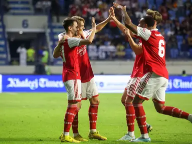 Gelandang Arsenal, Martin Odegaard (kedua kiri) berselebrasi dengan rekan satu timnya usai mencetak gol ke gawang AC Milan selama pertandingan Dubai Super Cup 2022 di di stadion al-Maktoum di Uni Emirat Arab (13/12/2022). Arsenal menang tipis atas AC Milan dengan skor 2-1. (AFP/Karim Sahib)