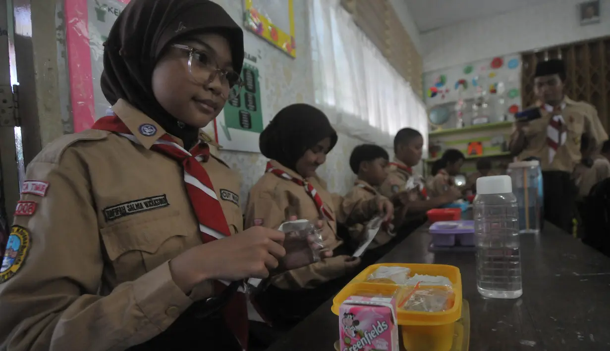 Siswa-siswi SDN 05 dan 07 Cipinang Melayu Kecamatan Makasar, Jakarta bersiap melakukan makan siang bersama, Rabu (7/8/2024). (merdeka.com/Imam Buhori)