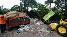 Petugas kebersihan membersihkan tumpukan sampah Tahun Baru 2018 di Monas, Jakarta, Senin (1/1). Setelah perayaan malam tahun baru 2018, jumlah sampah sisa mencapai 780 ton. (Liputan6.com/Faizal Fanani)