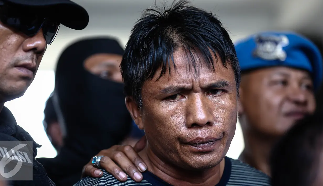 Ridwan Sitorus alias Ius Pane saat di Bandara Halim Perdana Kusumah, Minggu (1/1). Ius Pane ditangkap tim gabungan dari Polrestro Jakarta Timur, Polresta Depok dan Ditkrimum Polda Metro Jaya. (Liputan6.com/Faizal Fanani)