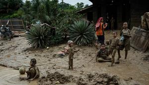 Kondisi lingkungan dan sanitasi yang kurang memadai pasca- bencana dapat memicu peningkatan kasus Infeksi Saluran Pernapasan Akut (ISPA), seperti batuk, pilek, hingga demam. Tampak dalam foto, anak-anak bermain di genangan lumpur di Pengidam, Aceh Tamiang, pada Senin 15 Desember 2025. (Yasuyoshi Chiba/AFP)