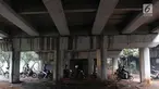 Pengendara motor melintasi jalan setapak di kolong tol di kawasan Lebak Bulus, Jakarta, Selasa (13/2). Untuk menghindari macet sebagian pengendara memanfaatkan jalan setapak tersebut untuk memersingkat waktu tempuh. (Liputan6.com/Immanuel Antonius)
