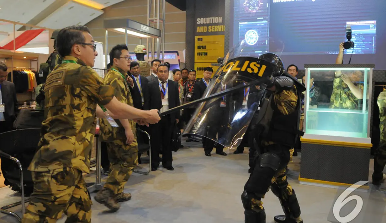 Aksi ujicoba kekuatan tameng anti huru-hara diperagakan dalam pameran Indo Defence 2014, JIExpo Kemayoran, Jakarta, Rabu (5/11/2014)(Liputan6.com/Herman Zakharia)