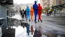 Anggota Prizma Ensemble berjalan di sekitar kota Yerusalem saat festival hari libur Yahudi Hanukkah, Israel (26/12). Prizma Ensemble sekelompok seniman yang sering tampil dengan pakaian polos warna-warni. (Reuters/Amir Cohen)