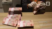 Teller menghitung mata uang Rupiah di Jakarta, Kamis (16/7/2020). Rupiah secara point to point pada triwulan II 2020 mengalami apresiasi 14,42 persen. (Liputan6.com/Angga Yuniar)