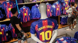 Pengunjung memilih jersey baru bernomor punggung 10 dari penyerang Barcelona asal Spanyol, Lamine Yamal di toko resmi FCB di Barcelona. (AFP/Manaure Quintero)