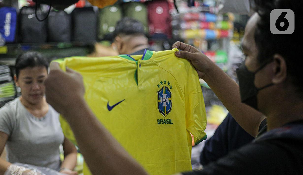 Pembeli melihat jersey Brasil tim peserta Piala Dunia 2022 Qatar di salah satu kios di Blok B Pasar Tanah Abang, Jakarta, Jumat (18/11/2022). Jersey sejumlah tim nasional favorit peserta Piala Dunia 2022 Qatar seperti Belanda, Brasil, Jerman, serta Argentina banyak diburu pembeli. (Liputan6.com/Faizal Fanani)